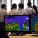 Thermal camera monitors show the body temperature of visitors.